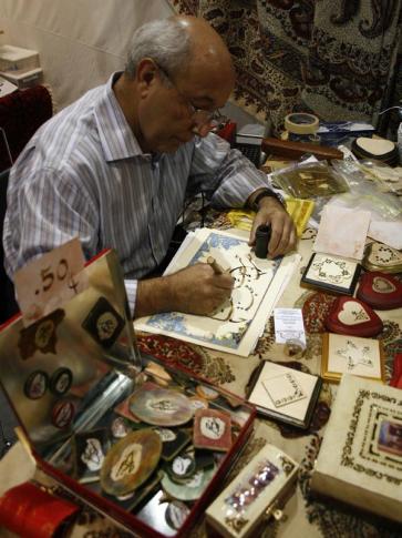 Freydoun Naeymirad delicately creates his calligraphy at the Iranian booth.
